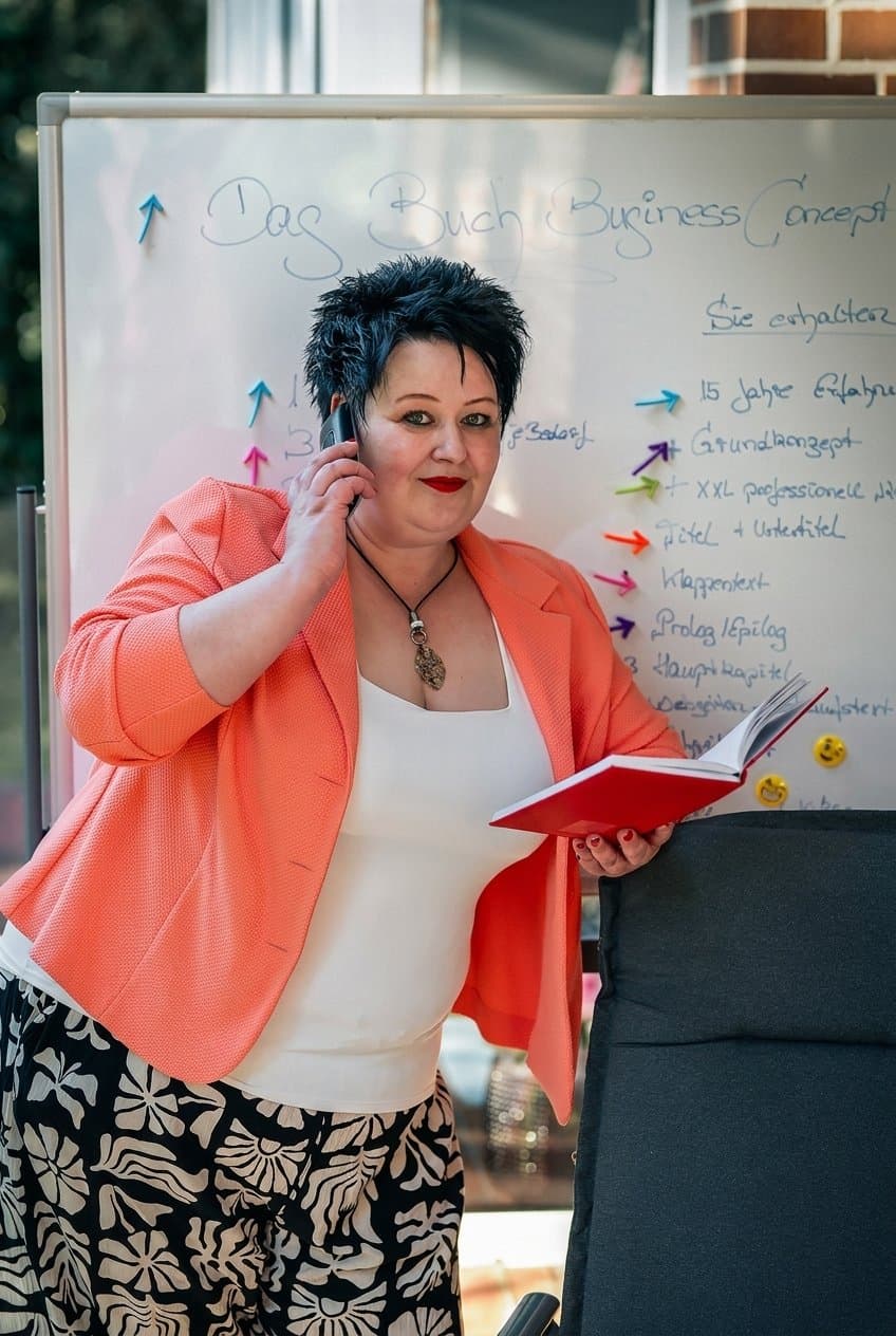 Nicole Lümken vor ihrem Whiteboard mit dem Buch Business Concept